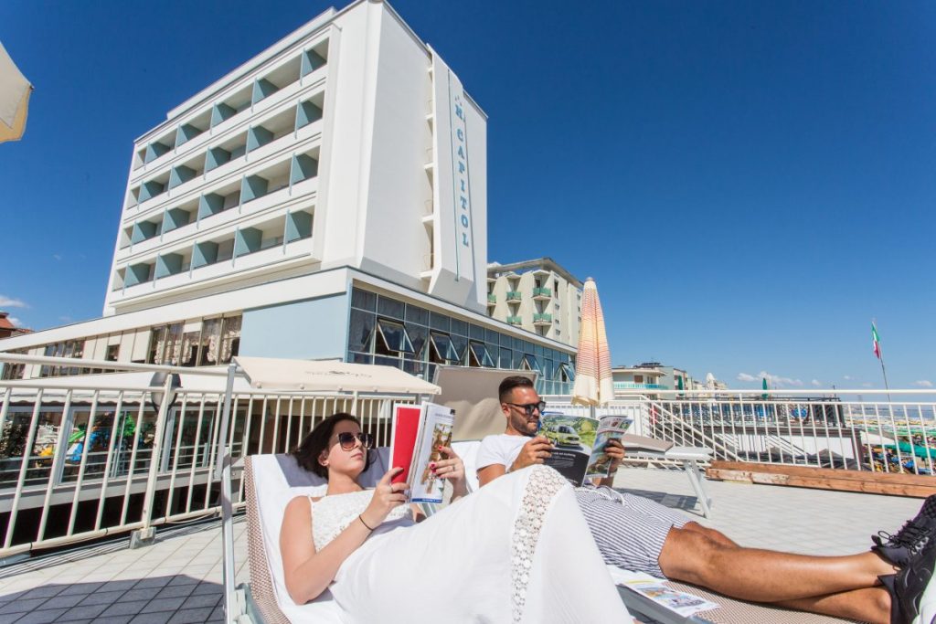 Giovane coppia legge sui lettini nella terrazza panoramica