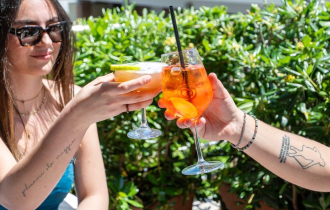 coppia brinda a bordo piscina con colorati drink