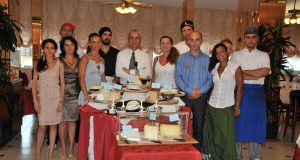 lo staff dell'hotel in posa davanti al buffet dei formaggi