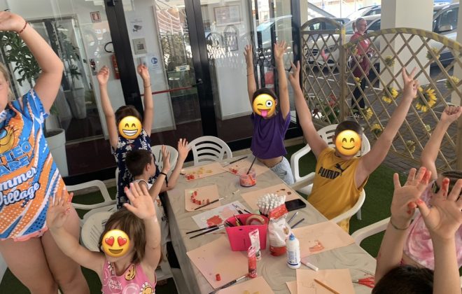 Bambini a un tavolo con colori e colla