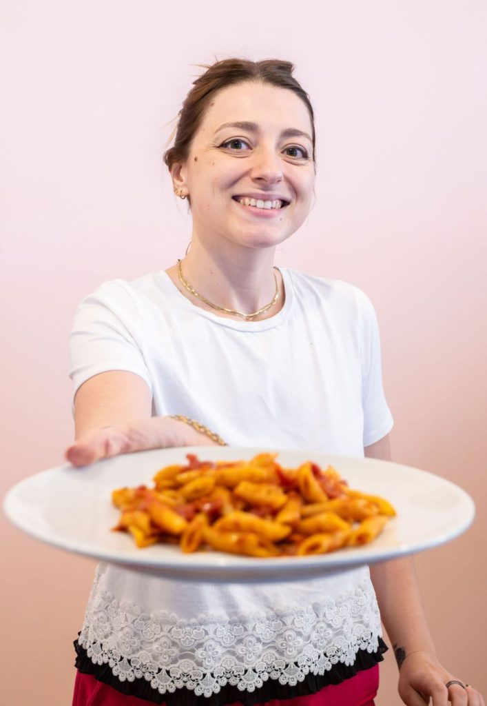 cameriera che consegna un piatto di pasta