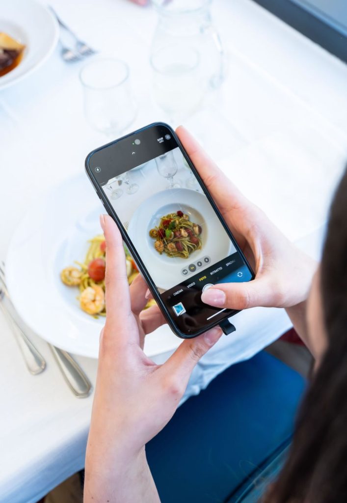 ragazza che fotografa un piatto di pasta