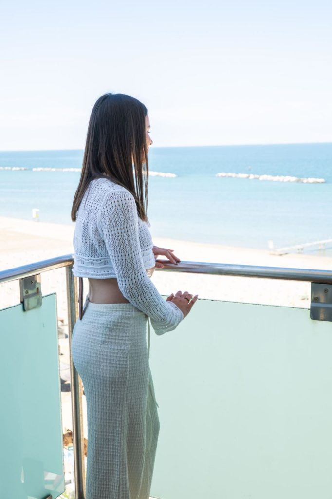 ragazza sul balcone che guarda il mare